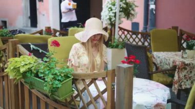 Kadın Smartphone dış kafede tarama. Dış restoranda masada oturan ve smartphone tarama neşeli kadın. 4k