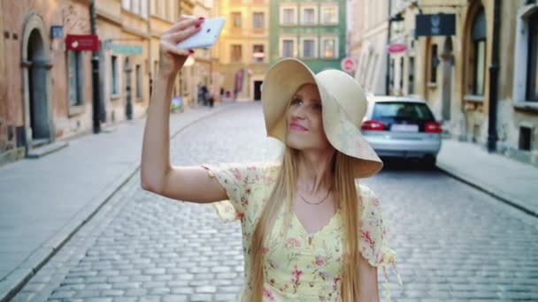 Kadın kareye selfie çekiyor. Çekici kadın selfie için poz veriyor ve şehir meydanında duruyor.. — Stok video