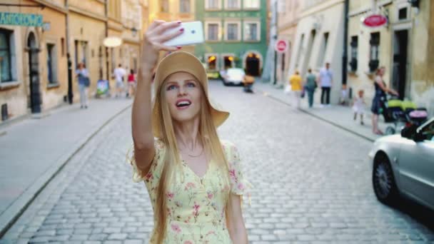 Een vrouw die rondkijkt en foto 's maakt. Vrolijke vrouw sightseeing en het nemen van foto 's op de oude stad straat. — Stockvideo