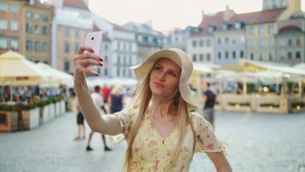 Frau macht Selfie auf dem Platz. Attraktive Frau posiert für Selfie und steht auf Stadtplatz. — Stockvideo