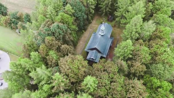 Houten kerk in kleine stad onder weiden. Drone beelden. — Stockvideo