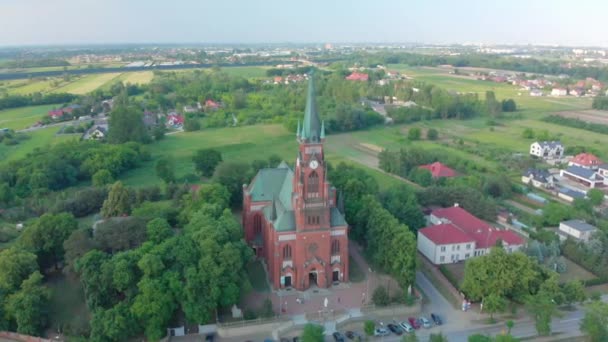 Igreja em cidade pequena entre pastagens. Imagens de drones. Igreja Vermelha é Igreja Católica Romana . — Vídeo de Stock