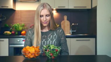 Genç Bayan çıtır salata için tercih. Çekici genç kadın şık mutfak masasında otururken kahvaltı için sağlıklı net yemek için tercih. 4k