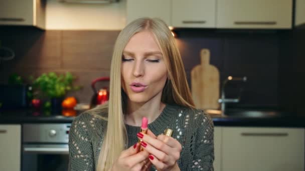 Junge Vlogger sprechen über Lippenstift für die Lippen. Attraktive junge Frau spricht über kosmetische Lippenstift für Lippen, während Dreharbeiten Video für Schönheit vlog in der Küche. — Stockvideo