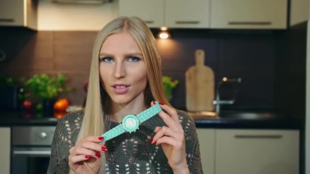 Mladý vlogger mluví o hodinkách. Atraktivní mladá žena mluví o náramkové hodinky při natáčení videa pro krásu vlog v kuchyni. — Stock video