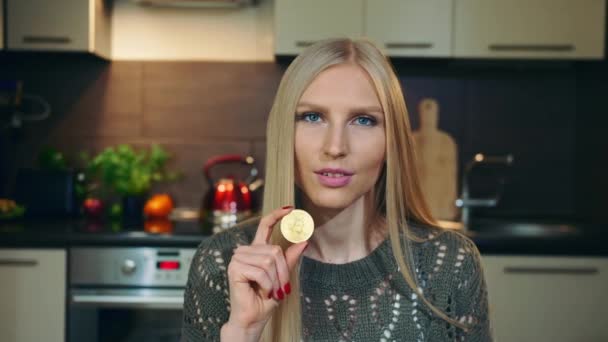 Jonge vlogger praat over Bitcoin. Aantrekkelijke jonge vrouw praten over Bitcoin tijdens het schieten video voor vlog in de keuken. — Stockvideo