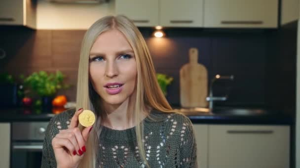 Ο νεαρός vlogger μιλάει για bitcoin. Ελκυστική νεαρή γυναίκα μιλάμε για bitcoin, ενώ γυρίσματα βίντεο για vlog στην κουζίνα. — Αρχείο Βίντεο