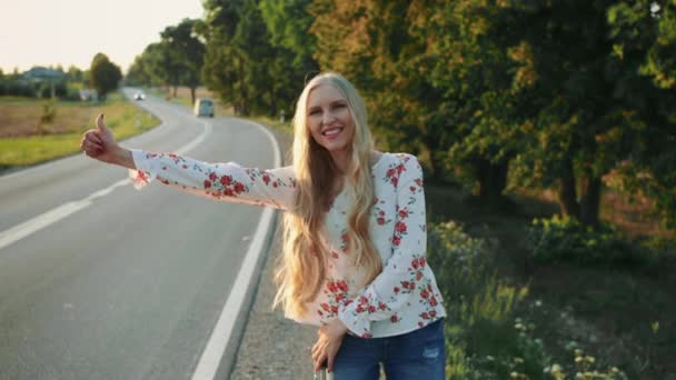 Traveler Girl hitchhiking on a sunny road and walking. — Stock Video