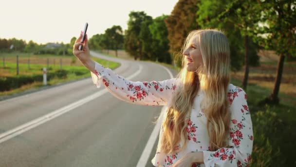 Женщина делает видеозвонок возле сельской дороги . — стоковое видео
