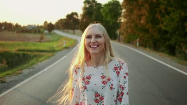 Mujer con sombrero corriendo por la carretera . — Vídeos de Stock