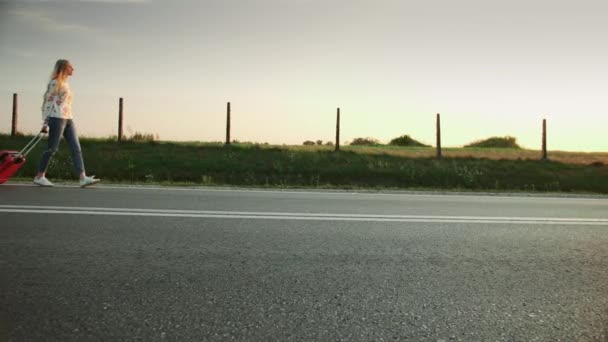 Glada ung dam med resväska promenader på vägen. — Stockvideo