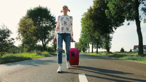 Joyeux jeune femme avec valise marchant sur la route . — Video