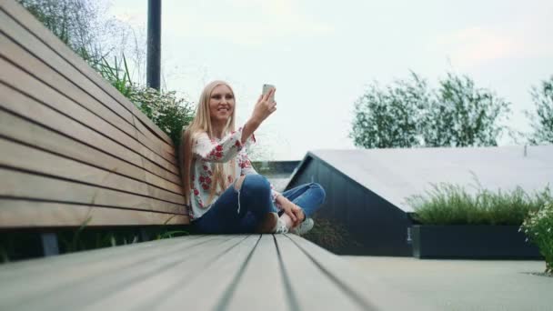Jovencita haciendo videollamada en techo verde . — Vídeo de stock
