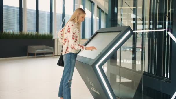 Vrouw bij navigatiebord in winkelcentrum. — Stockvideo