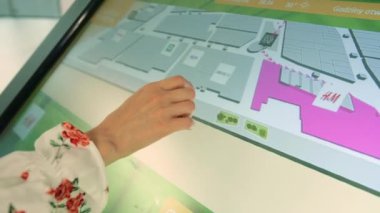 Alışveriş merkezinde navigasyon kartı kullanan isimsiz bir kadın..