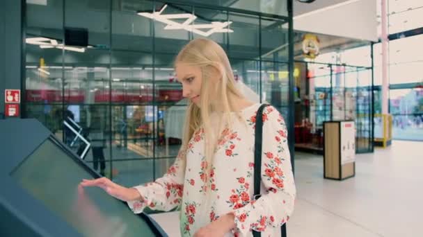 年轻女性在现代商场的导航板上寻找正确的方向. — 图库视频影像
