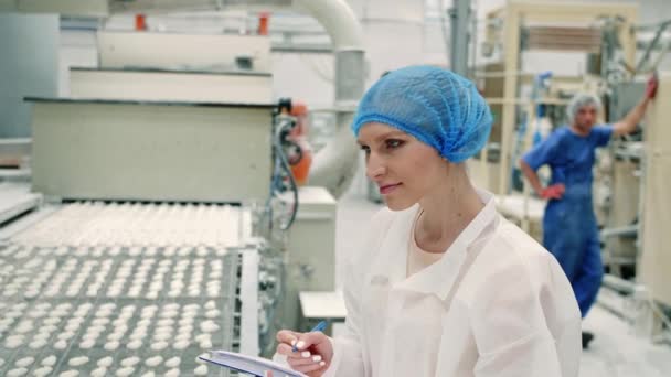 Candy factory. Controller checking conveyor with candies. — Stock Video