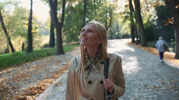 Hermosa mujer rubia caminando en el parque en otoño — Vídeos de Stock