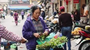 Hanoi Vietnam 'ın Eski Kasabası' ndaki sokak pazarında satıcı. Sokakta yemek için marul satan kadın..