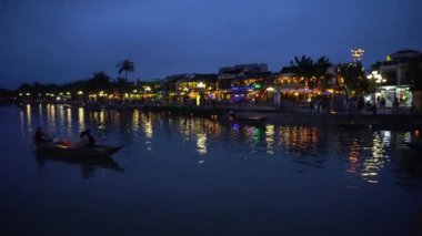 Yüzen fenerler ve teknelerle gece nehri manzarası. Hoi An, Vietnam