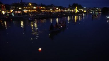 Yüzen fenerler ve teknelerle gece nehri manzarası. Hoi An, Vietnam