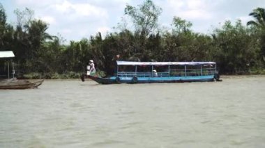 Geleneksel Vietnam feribotu insanları ve bisikletlerini Vietnam, Güneydoğu Asya 'daki Mekong Nehri' nden geçiriyor.