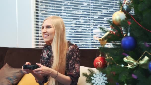 Primer plano de la mujer emocionada pierde el juego en playstation cerca del árbol de Navidad — Vídeos de Stock