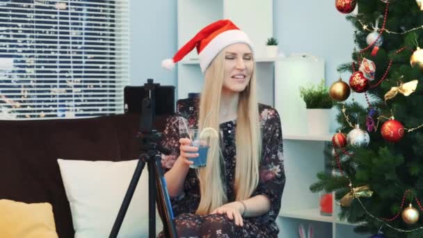 Superbe femme dans Santa chapeau enregistrement vidéo vlog par smartphone sur trépied — Video