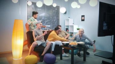 Çok ırklı arkadaşlar televizyon izlemek için kanepede yatıyorlar.