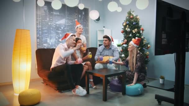 Διαφορετική ομάδα φίλων σε Σάντα καπέλα και μάσκες κόμμα κάνοντας προπόσεις τα Χριστούγεννα — Αρχείο Βίντεο