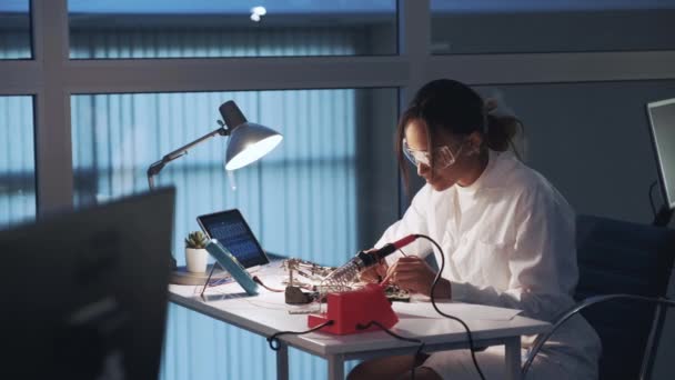 Especialista en electrónica afroamericana haciendo pruebas en tablero electrónico con probador de multímetros en laboratorio — Vídeo de stock