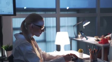 Modern laboratuvarda bilgisayar üzerinde çalışan profesyonel elektronik uzmanının yan görünümü