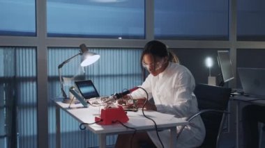 Afrika kökenli Amerikalı elektronik uzmanı. Laboratuvarda çoklu metre testçisi ve diğer elektronik cihazlarla çalışıyor.