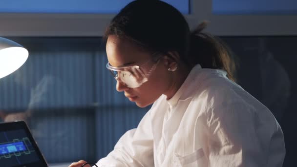 Close up of african american engineer in protective glasses working in electronics lab — Stock Video