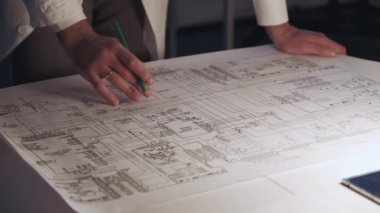 Kontrol elektroniği şeması hakkında notlar yapan mühendislerin ellerinin kapatılması