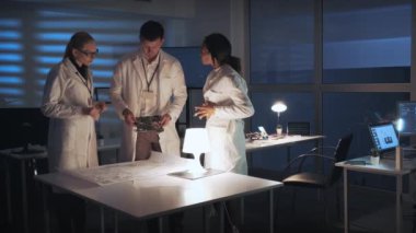 Teknoloji Araştırma Laboratuvarı: Çeşitli mühendisler anakart ve elektronik şeması ile elektronik gelişimi tartışıyor