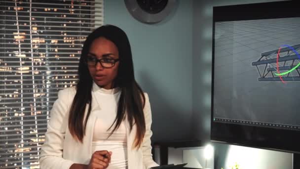 Женщина-чёрный архитектор обсуждает с коллегой 3D модель мостового компонента на большом экране — стоковое видео