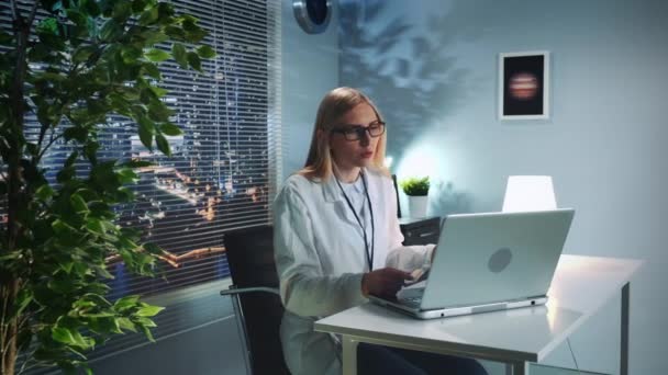 Online pszichológus terápia: nő laborköpenyben videohívást kezdeményez a beteggel számítógépen — Stock videók