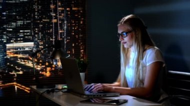 Mutlu genç bir kadın gece geç saatlerde internet dükkanından karlı bir alışveriş yapıyor.