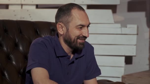 Feliz padre con barba sentado en sillón de cuero — Vídeos de Stock