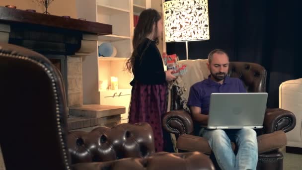 Папа слишком занят, чтобы играть со своей красивой дочерью, работающей за компьютером. — стоковое видео