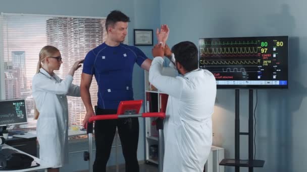 Médecins mettant des électrodes sur les sportifs debout sur l'hippodrome — Video