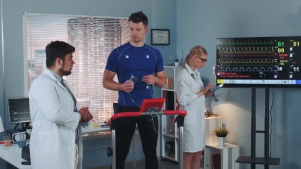 Mixed race sport scientist giving athlete instructions how to make the test properly — Stock Video