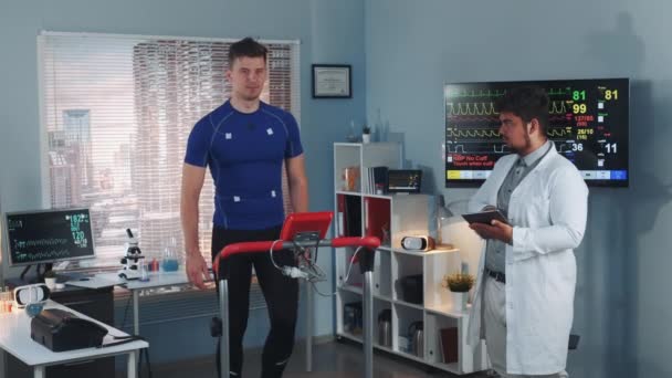 Multirasowy profesjonalny Sport wykonywania stress test, podczas gdy sportowiec chodzenie na bieżni — Wideo stockowe