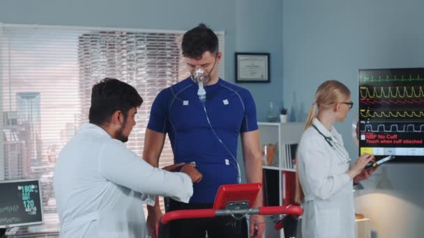 Doktor oksijen maskeli sporcuyu kardiyo solunum testi için hazırlıyor. — Stok video