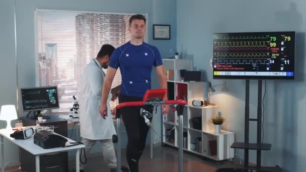 Vegyes Race orvos ellenőrzése sportoló fitness szinten, miközben sétált a versenypályára — Stock videók