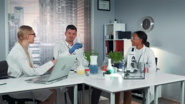 Equipe multirracial feliz de cientistas fazendo torradas com coquetéis de gelo seco em frascos — Vídeo de Stock