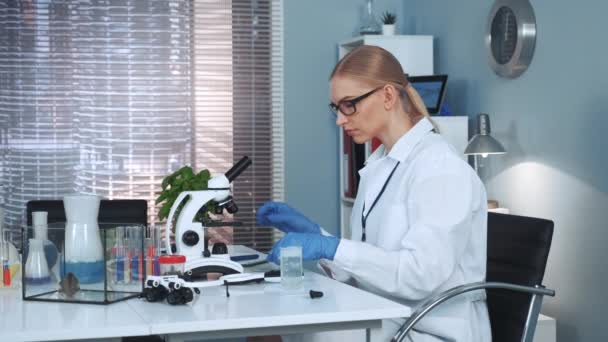 Cientista feminina fazendo experimentos com materiais orgânicos em laboratório de química — Vídeo de Stock