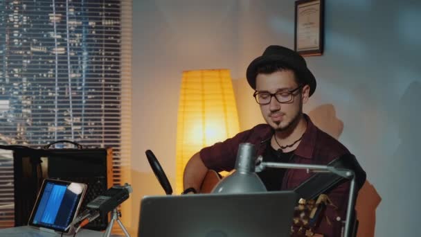 Estudio de grabación en casa: joven músico en sombrero cantando y tocando la guitarra — Vídeos de Stock