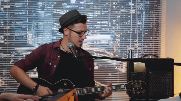 Joven músico grabando una canción y tocando la guitarra en el estudio casero — Vídeos de Stock
